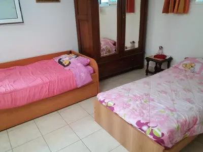 two beds in a room with pink sheets and a mirror at Aliki House in Porto Rafti