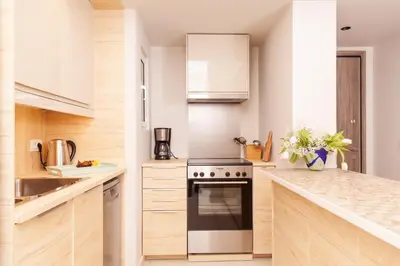 a kitchen with white cabinets and a stove top oven at Sweet Suite Flora in Vouliagmeni in Athens