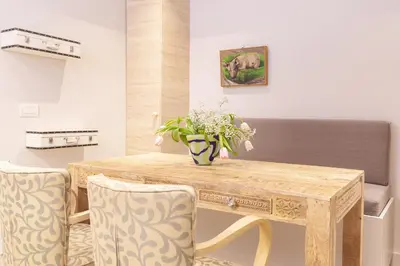 a dining room with a wooden table and chairs at Sweet Suite Flora in Vouliagmeni in Athens