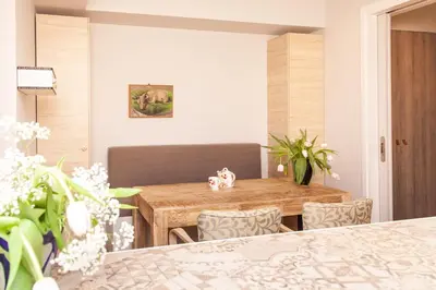 a dining room with a wooden table and chairs at Sweet Suite Flora in Vouliagmeni in Athens