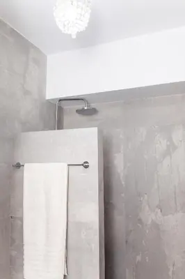 a bathroom with a white towel hanging on a towel rack at Sweet Suite Flora in Vouliagmeni in Athens