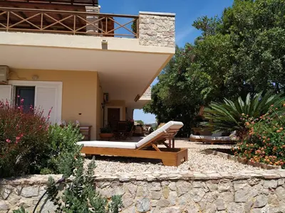 a patio of a house with a couch in a yard at Villa Vena in Palaiá Fókaia