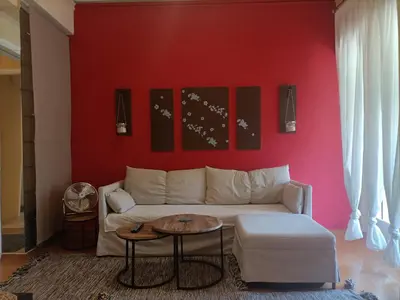 a living room with a white couch and a red wall at Charming Retreat in Athens