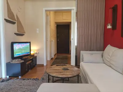 a living room with a couch and a tv at Charming Retreat in Athens