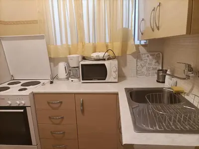 a small kitchen with a sink and a microwave at Charming Retreat in Athens