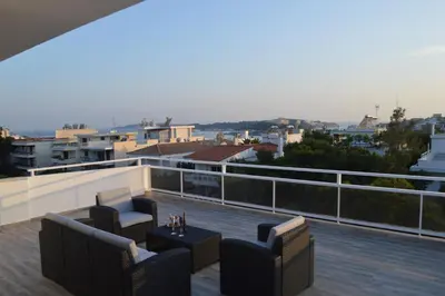 a patio with two chairs and a table on a balcony at Athens Riviera Loft in Athens