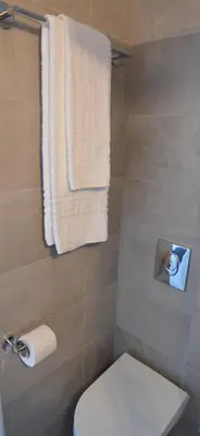 a bathroom with a white toilet and towels at Athens Riviera Loft in Athens