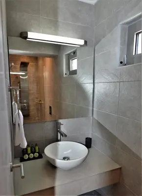 a bathroom with a white sink and a mirror at Athens Riviera Loft in Athens