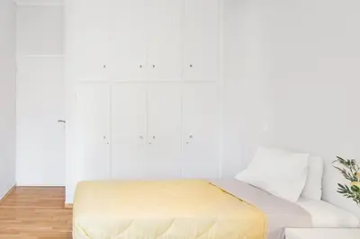 a white room with a mattress on a couch at Koukaki Apartment with a Sunny Balcony, near the Acropolis in Athens