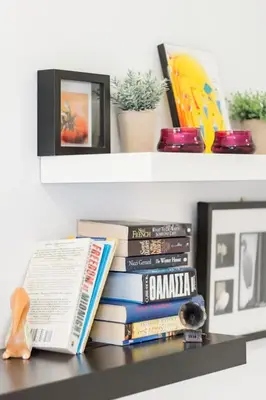 a pile of books sitting on top of a shelf at Koukaki Apartment with a Sunny Balcony, near the Acropolis in Athens