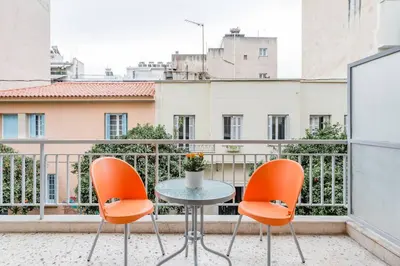 a small table and two chairs on a balcony at Koukaki Apartment with a Sunny Balcony, near the Acropolis in Athens