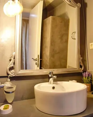 a bathroom with a white sink and a mirror at Lycabettus Exclusive Apartments in Athens