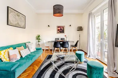 a living room with a blue couch and a table at 3BDR IDEAL CENTRAL ATHENIAN APT in Athens