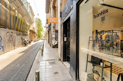 an empty street in a city with a store window at 3BDR IDEAL CENTRAL ATHENIAN APT in Athens