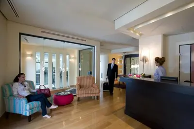 a man in a suit is standing in a lobby at O&B Athens Boutique Hotel in Athens