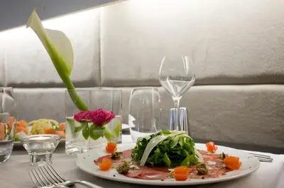 a plate of food on a table with wine glasses at O&B Athens Boutique Hotel in Athens