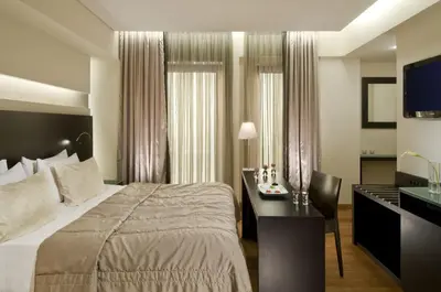 a hotel room with a bed and a desk and a television at O&B Athens Boutique Hotel in Athens