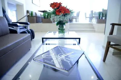 a living room with a glass table with a vase of flowers at Phidias Hotel by Oniro in Athens