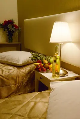 a table with a lamp and a bowl of fruit on it at Phidias Hotel by Oniro in Athens