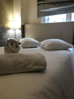 a bed with two pillows and a blanket on it at Phidias Hotel by Oniro in Athens