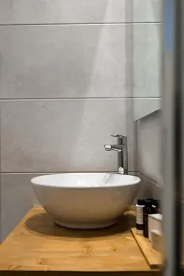 a white bowl sink on a wooden table in a bathroom at Urban Chic 1BD Apartment in Hilton district by UPSTREET in Athens
