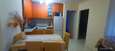 a kitchen with a table and a white refrigerator at Penthouse Deluxe apartment at piraeus in Piraeus