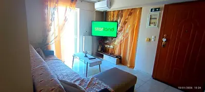 a living room with a couch and a tv on the wall at Penthouse Deluxe apartment at piraeus in Piraeus