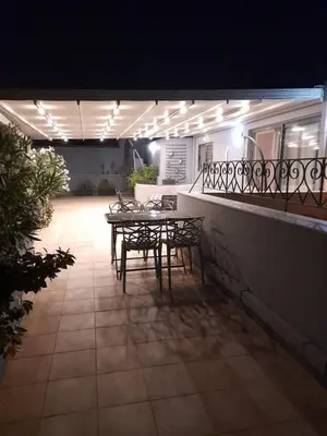 a table and chairs on a patio at night at V&V Acropolis view apartment in Athens
