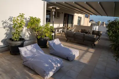 two pillows on a patio with a table and chairs at V&V Acropolis view apartment in Athens