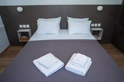 a bedroom with a bed with two towels on it at V&V Acropolis view apartment in Athens