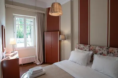 a bedroom with a large bed and a window at The Hadrian Wall - A Historic Acropolis Villa in Athens