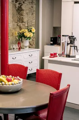 a kitchen with a table with a bowl of fruit on it at The Hadrian Wall - A Historic Acropolis Villa in Athens