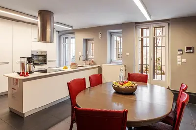 a kitchen with a table with a bowl of fruit on it at The Hadrian Wall - A Historic Acropolis Villa in Athens