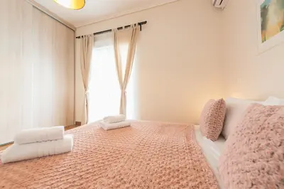 a bedroom with a pink bed with a window at Stylish Athenian Flat in Athens