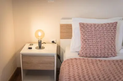 a bedroom with a bed and a lamp on a night stand at Stylish Athenian Flat in Athens