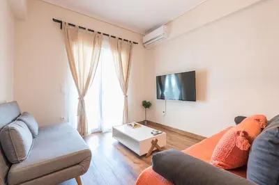 a living room with a couch and a tv at Stylish Athenian Flat in Athens