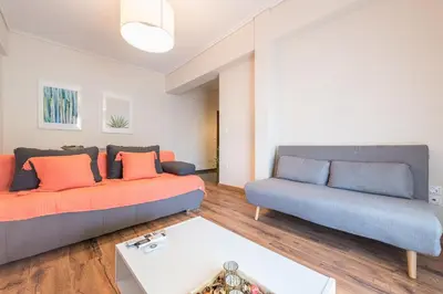 a living room with two couches and a table at Stylish Athenian Flat in Athens