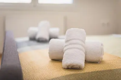 four white towels sitting on top of a bed at Just Under Acropolis in Athens