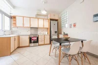 a kitchen with a black table and white chairs at Just Under Acropolis in Athens