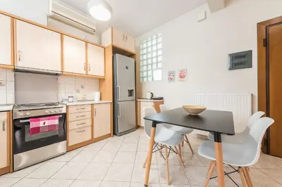 a kitchen with a black table and white chairs at Just Under Acropolis in Athens