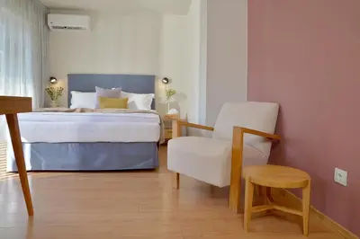 a bedroom with a bed and a chair at MIRIVILI hospitality & wellness in Athens