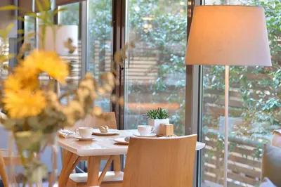 a table with a lamp and a table with cups on it at MIRIVILI hospitality & wellness in Athens