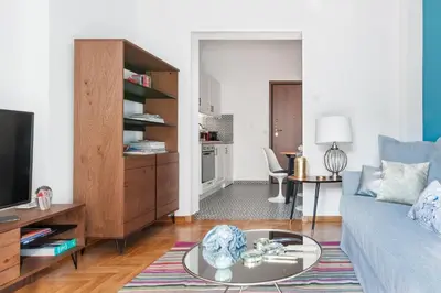 a living room with a blue couch and a tv at Retropolitan Living Athens in Athens