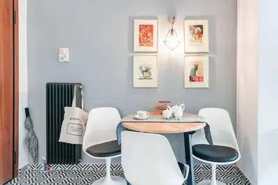 a dining room with a table and white chairs at Retropolitan Living Athens in Athens