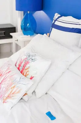 a bed with white sheets and pillows on it at Retropolitan Living Athens in Athens