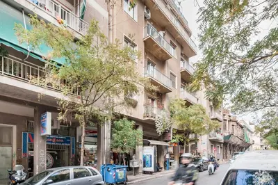 a person riding a motorcycle down a city street at Retropolitan Living Athens in Athens