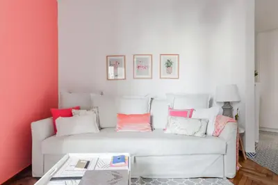 a living room with a white couch with pink walls at Retropolitan Living Athens in Athens