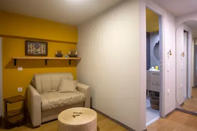 a living room with a chair and a stool at The Frogs_Guest House in Athens