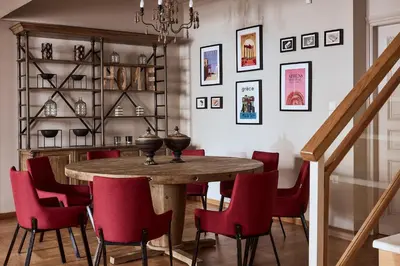 a dining room with a wooden table and red chairs at Plaka's Villa with Breathtaking Acropolis view in Athens