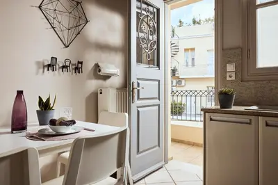 a kitchen with a white table and chairs and a door at Plaka's Villa with Breathtaking Acropolis view in Athens